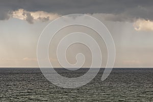 Mysterious rain clouds in the sky and  wavy sea