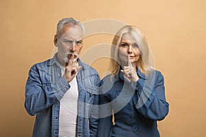 Mysterious retired man and woman showing silent gesture