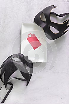 Mysterious Venetian masks with a tray and a card for a message. Mysterious date.