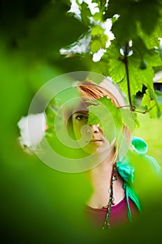 Mysterious woman behind leaves