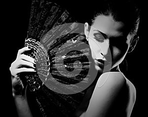 Mysterious woman holding a fan black and white