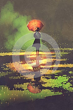 Mysterious woman holds umbrella standing in a puddle photo