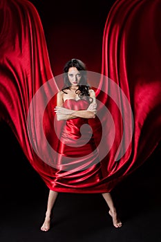 Mysterious woman in red waving silk dress