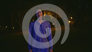 Mysterious woman standing solitude illuminated by park night lanterns closeup