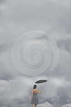 Mysterious woman with umbrella goes to meet the threatening clouds