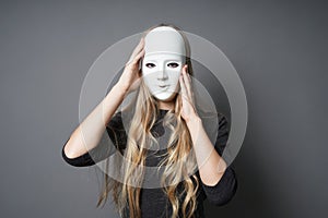 Mysterious young woman adjusting her mask