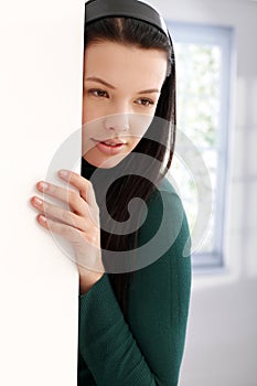 Mysterious young woman leaning to wall thinking