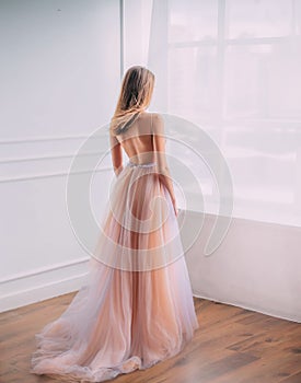 woman princess in elegant airy luxury long evening trendy dress bare open back. photo