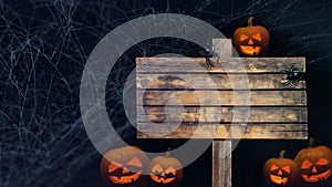 Mystery Halloween holiday party card background - Old blank weathered wooden sign with spider, spider webs and glowing spooky
