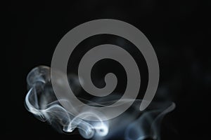 Mystery light blue smoke over dark background with copy space