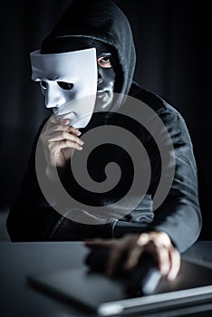 Mystery man in black mask holding white mask