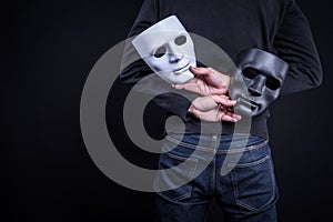 Mystery man holding black and white mask