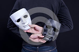 Mystery man holding black and white mask