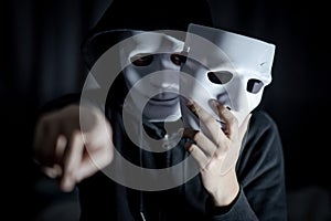 Mystery man pointing and holding white mask