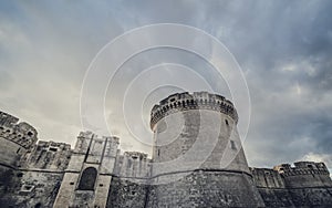 Mystery ruins of medieval old tower of castle under dark scary cloudy sky in Matera Italy