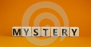 Mystery symbol. The concept word Mystery on wooden cubes. Beautiful orange table, orange background, copy space. Business and