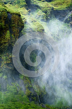 Mystery waterfall flowing with foggy in lush canyon