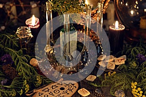 Alchemy still life with glass bottles and flask, runes, healing herbs and ritual objects