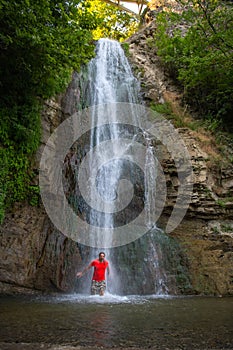 Mystic Encounter: Man in Red Transfixed by the Waterfall