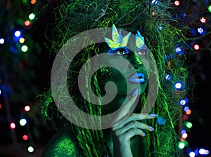 Mystic green dryad in UV fluor black light with Glowing trees on background