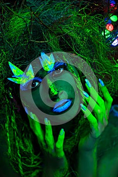 Mystic green dryad in UV fluor black light with Glowing trees on background