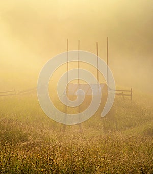 Mystic landscape from the haystack in the morning fog in the mountains among the mountain valleys
