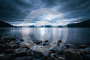 Mystic landscape lake scenery in Scotland: Cloudy sky, sunbeams and mountain range in loch Linnhe