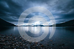 Mystic landscape lake scenery in Scotland: Cloudy sky, sunbeams and mountain range in loch Linnhe