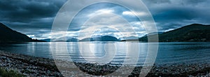 Mystic landscape lake scenery in Scotland: Cloudy sky, sunbeams and mountain range in loch Linnhe