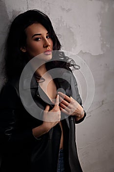 Mystic passion woman in leather black jacket on dark shadow background. Closeup art portrait