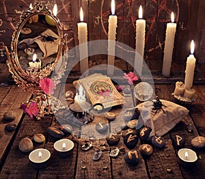Mystic ritual with burning candles, magic mirror, flowers and the tarot cards