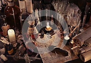 Mystic still life with alchemy paper, vintage bottles, candles and magic objects