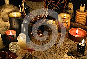 Mystic still life with demon manuscript, mirror and black candles