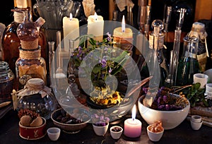 Mystic still life with herbs, bottles, candles and flasks photo