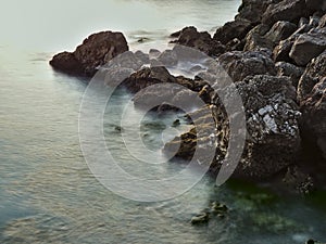 Mystic water and rocks at the ocean - Long exposure nice lanscape with stones on the sea beach. View of water like fog and mist