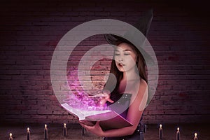 Mystical of a beautiful asian witch woman with a magic book