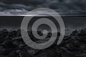 Mystical foggy sea and rocky shore in the evening