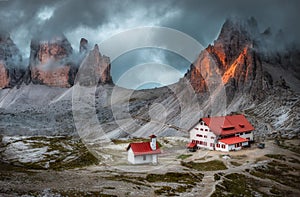 Mystical landscape with rocky mountains house and beautiful church at dusk Italian alps Tre Cime park in Dolomites Italy