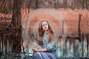 Mystical portrait of redheaded girl in the swamp