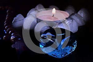 mystical still life. burning candles, rosaries and magic glass stones on a dark background. the concept of divination.