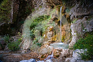 Mystically atmospheric waterfall with green moss and rocks