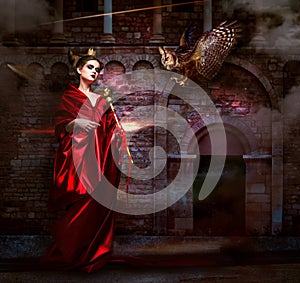 Mysticism. Witchcraft. Sorcerer in Red Mantle with Vulture - Hawk. Ancient Scary Castle