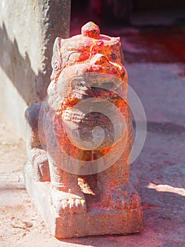 Mythological lion with red pigment guarding shrine at Kali Temple, worshiping Goddess Kali at Dhulikhel in Nepal