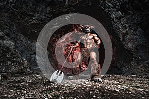 Mythological Minotaur  half bull half man stands in a rock cave in an aggressive stance