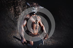 Mythological Minotaur  half bull half man stands in a rock cave in an aggressive stance