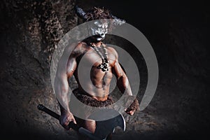 Mythological Minotaur  half bull half man stands in a rock cave in an aggressive stance photo