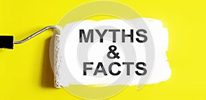 MYTHS AND FACTS .One open can of paint with white brush on it on yellow background. Top view