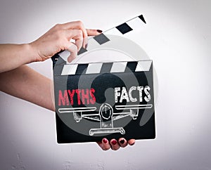 Myths vs Facts Balance. Female hands holding movie clapper