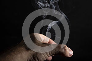 MÃÂ£o tentando pegar a fumaÃÂ§a branca do incenso photo