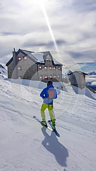 Mölltaler Gletscher - A skier standing in front of a Alpine cottage